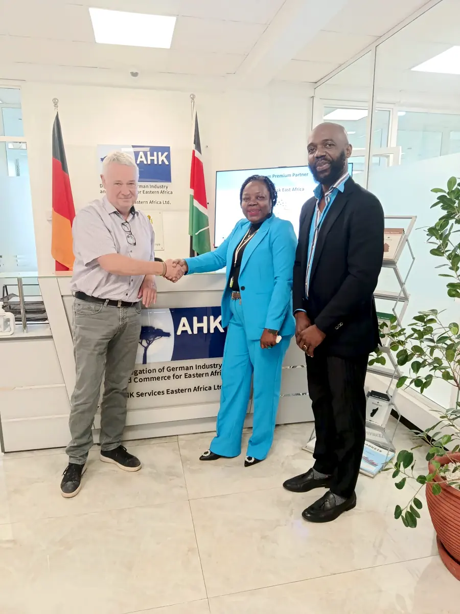 Handschlag am Empfang der AHK Ostafrika in Nairobi, dahinter das AHK-Logo und beide Flaggen